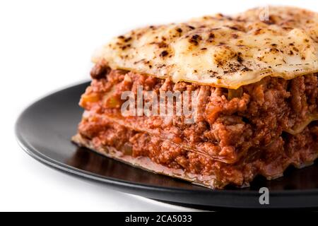 Pezzetto di lasagne di carne su piastra nera isolato su fondo bianco Foto Stock
