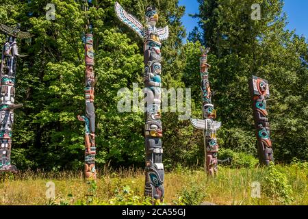 Vancouver, Canada - 27 Luglio 2017: Totem Poles a Stanley Park a Vancouver, con boschi sullo sfondo, British Columbia, Canada Foto Stock