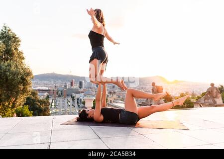 Due belle donne che fanno acroyoga in città Foto Stock