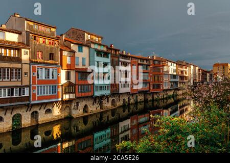 Europa, Francia, Occitanie, Midi-Pirenei, Tarn, Castres, case sull'Agout, vista di edifici lungo le rive del fiume sotto un cielo tempestoso
