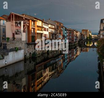 Europa, Francia, Occitanie, Midi-Pirenei, Tarn, Castres, case sull'Agout, vista di edifici lungo le rive del fiume sotto un cielo tempestoso