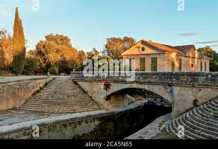 Francia, Aude, Canal du Midi, patrimonio mondiale dell'UNESCO, Gailhousty, edificio storico lungo la serratura in autunno al tramonto Foto Stock