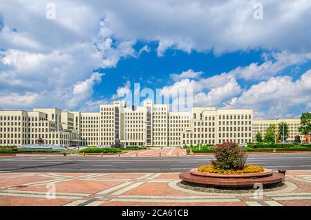 L'edificio in stile costruttivismo della Casa del Governo e la statua di Vladimir Lenin sulla Piazza dell'Indipendenza nel centro storico della città di Minsk, le nuvole bianche del cielo blu nella soleggiata giornata estiva, Repubblica di Bielorussia Foto Stock