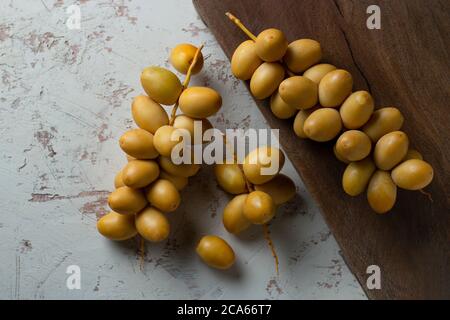 date gialle fresche su sfondo di legno Foto Stock