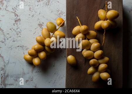 date gialle fresche su sfondo di legno Foto Stock