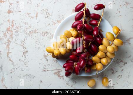 frutta fresca datteri in piatto bianco Foto Stock