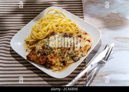Cucina italiana pollo Lombardia con sugo di funghi marsala e linguine Foto Stock