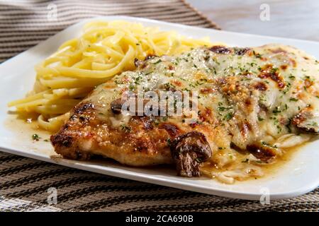 Cucina italiana pollo Lombardia con sugo di funghi marsala e linguine Foto Stock