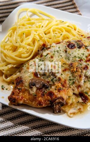 Cucina italiana pollo Lombardia con sugo di funghi marsala e linguine Foto Stock