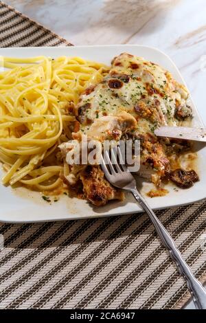 Cucina italiana pollo Lombardia con sugo di funghi marsala e linguine Foto Stock