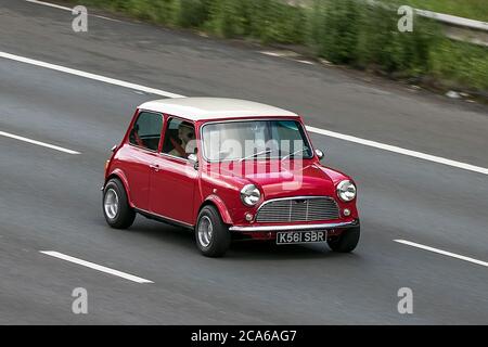 Un 1992 Rover Mini Mayfair Red Car Saloon benzina guida sulla M6 autostrada vicino Preston a Lancashire, Regno Unito Foto Stock