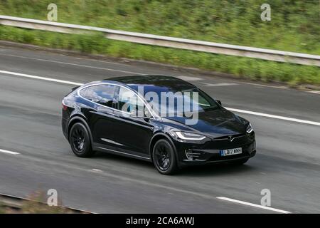 Un 2017 nero Tesla Model X 100D auto SUV Elettricità guida sulla M6 autostrada vicino Preston a Lancashire, Regno Unito Foto Stock