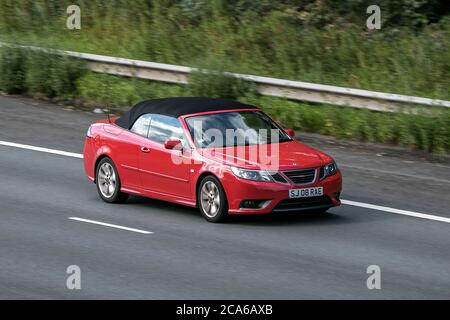 A 2010 Red Saab 9-3 Linear se Turbo benzina cabriolet cabriolet cabriolet soft top che guida sull'autostrada M6 vicino Preston a Lancashire, Regno Unito Foto Stock