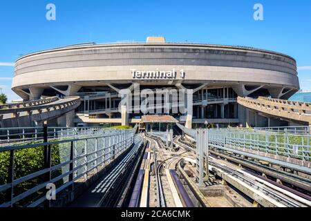 Vista frontale dell'edificio circolare in cemento del Terminal 1 dell'aeroporto di Parigi-Charles de Gaulle, visto dalla navetta dell'aeroporto CDGVAL in una giornata di sole. Foto Stock