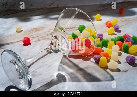 Gocce di caramella ricoperte di zucchero granulato versate in vetro martini Foto Stock