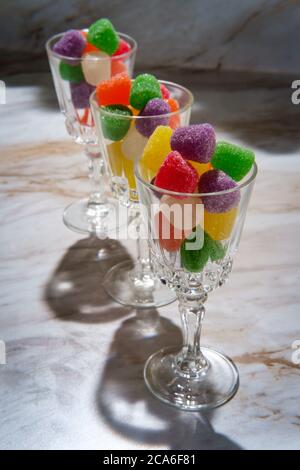 Gocce di caramella ricoperte di zucchero granulato in bicchieri da shot Foto Stock