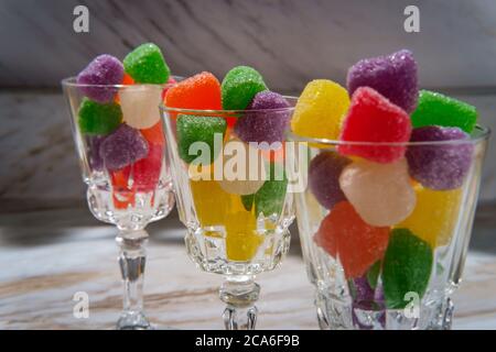 Gocce di caramella ricoperte di zucchero granulato in bicchieri da shot Foto Stock