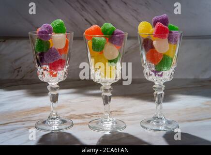 Gocce di caramella ricoperte di zucchero granulato in bicchieri da shot Foto Stock