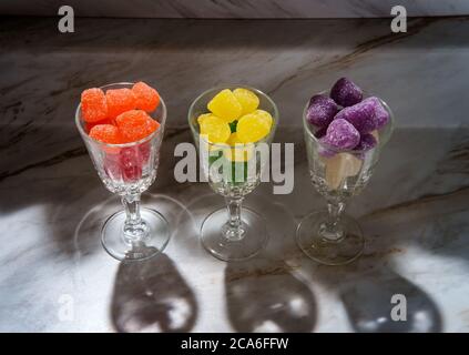 Gocce di caramella ricoperte di zucchero granulato in bicchieri da shot Foto Stock