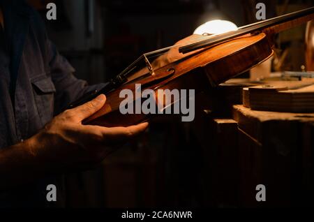 Liutaio artigiano che istituisce un violino nella sua officina Foto Stock