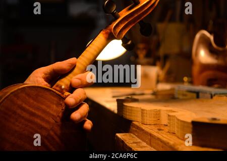 Liutaio artigiano che istituisce un violino nella sua officina Foto Stock