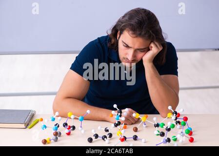 Giovane scienziato seduto in classe Foto Stock