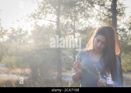 Bella giovane spagnola ragazza in retroilluminazione godendo la foresta Foto Stock