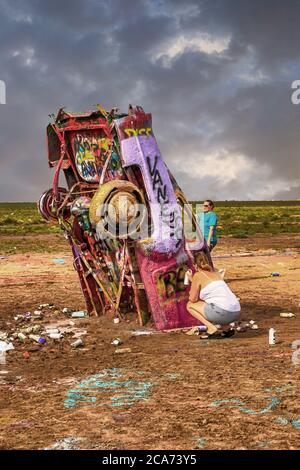 Cadillac Ranch con i suoi veicoli altamente verniciati nel mezzo di un campo fangoso appena fuori Amarillo, Texas Foto Stock