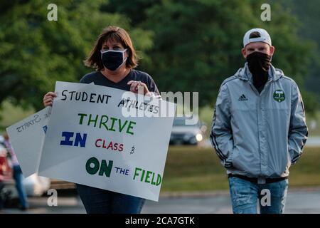 Copley, Ohio, Stati Uniti. 4 agosto 2020. Studenti, genitori e personale di Copley-Fairlawn City Schools protestano al di fuori del consiglio di amministrazione della scuola poco prima di un voto stabilito per decidere il futuro dell'apprendimento di persona a causa di preoccupazioni sulla trasmissione COVID-19, Martedì, 4 agosto 2020 a Copley, Ohio. Il consiglio di amministrazione voterà a favore dell'apprendimento a distanza per le prime nove settimane di scuola. Inoltre, tutte le attività atletiche e della band sono state sospese per quel periodo, secondo un comunicato stampa della scuola. Le decisioni relative alla sede per l'apprendimento sono state finora lasciate ai singoli Foto Stock