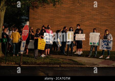 Copley, Ohio, Stati Uniti. 4 agosto 2020. Studenti, genitori e personale di Copley-Fairlawn City Schools protestano al di fuori del consiglio di amministrazione della scuola poco prima di un voto stabilito per decidere il futuro dell'apprendimento di persona a causa di preoccupazioni sulla trasmissione COVID-19, Martedì, 4 agosto 2020 a Copley, Ohio. Il consiglio di amministrazione voterà a favore dell'apprendimento a distanza per le prime nove settimane di scuola. Inoltre, tutte le attività atletiche e della band sono state sospese per quel periodo, secondo un comunicato stampa della scuola. Le decisioni relative alla sede per l'apprendimento sono state finora lasciate ai singoli Foto Stock