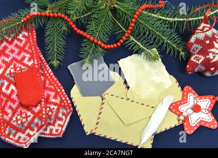 Still life con busta postale, vecchia lettera di carta, tagli a maglia e sempreverdi. Natale e Capodanno sfondo per carte, inviti, mockup. In alto Foto Stock