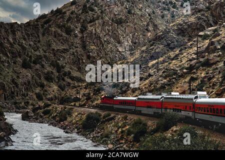 Royal Gorge Railway che corre accanto a una scogliera rocciosa nella gola reale della città canonica accanto al fiume Arkansas Foto Stock