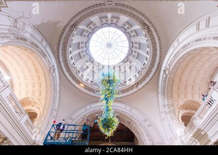 Il tecnico del Museo Andy Monk pulisce il lampadario in vetro Rotunda di 27 piedi di Dale Chihuly, che è composto da 1,300 elementi in vetro blu e verde, al Victoria and Albert Museum di Londra, mentre si prepara a riaprire al pubblico il 6 agosto. Foto Stock