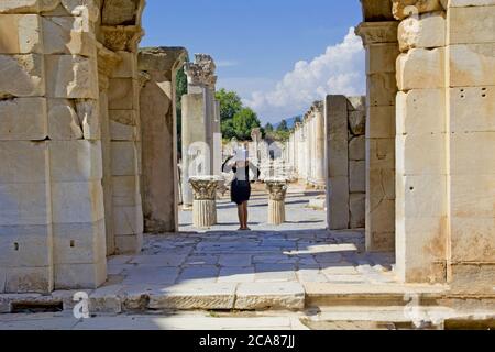 Bella giovane donna in abito nero nella città antica di Efeso Foto Stock