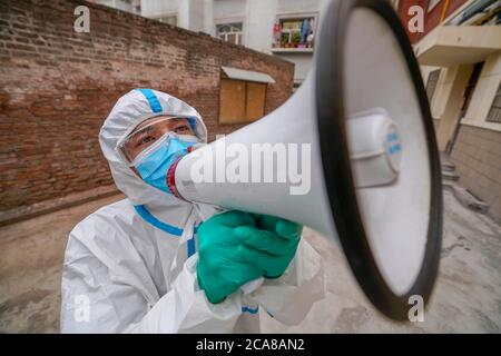 (200805) -- URUMQI, 5 agosto 2020 (Xinhua) -- Volontario Ekebar Emet pubblicizza misure di prevenzione delle epidemie in una comunità nel distretto di Tianshan di Urumqi, regione autonoma di Xinjiang Uygur, 3 agosto 2020. Ekebar Emet, uno studente di 21 anni, proviene dalla contea di Bachu, Xinjiang. Si recò alla comunità Dongcaiyuan nel distretto di Tianshan, a Urumqi, per praticare per un anno il 3 giugno. L'improvvisa rinascita di COVID-19 nello Xinjiang ha immediatamente trasformato Ekebar da un interno universitario ad un volontario in prima linea nella prevenzione e nel controllo delle epidemie. Ekebar pubblicizza Foto Stock