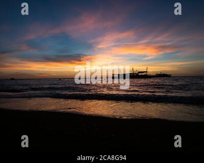 Alba sulla spiaggia nelle Filippine. Barche da immersione in attesa di subacquei al mattino presto. Foto Stock