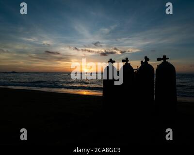 Alba sulla spiaggia nelle Filippine. Barche da immersione in attesa di subacquei al mattino presto. Silhouette di vasche da immersione in primo piano. Foto Stock