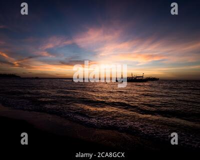 Incredibile alba sulla spiaggia delle Filippine. Barche da immersione in attesa di subacquei al mattino presto. Foto Stock