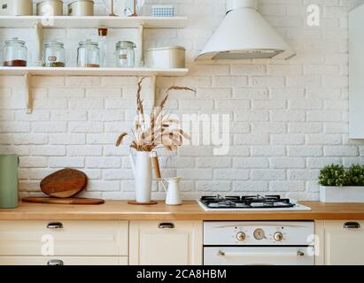 Interno cucina con utensili da cucina e piano cottura. Stile Scandi. Foto Stock