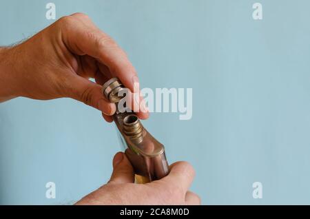 Matraccio in sughero con apertura a mano. Mani da uomo con un piccolo pallone per l'alcol. Razza europea maschile, 43-45 anni. Stile di vita Foto Stock