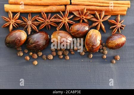 Natale o spezie di zucca su sfondo di legno. Ingredienti alimentari: Anice stellato, bastoncini di noce moscata e cannella, spezie. Foto Stock