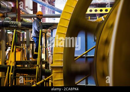 Akbakay/Kazakhstan - Aprile 23 2012: Controllo operaio del laminatoio di minerale (macinacaffè di fabbrica) in officina di fabbrica. Estrazione e lavorazione dell'oro pl Foto Stock