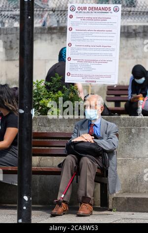 Un anziano protestore in maschera di faccia ascolta un discorso a Marble Arch, durante una dimostrazione di Black Lives Matter, Londra, 2 agosto 2020 Foto Stock