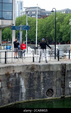 I turisti visitano il porto di Bristol, dove la statua di Edward Colston è stata ribaltata durante la dimostrazione Black Lives Matter del giugno 2020 Foto Stock