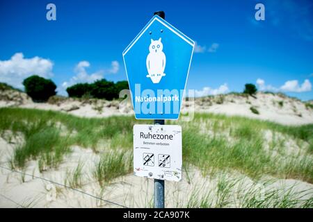 Norderney, Germania. 11 Luglio 2020. Un cartello con l'iscrizione 'Parco Nazionale' si trova di fronte al paesaggio delle dune all'estremità orientale dell'isola. L'accesso all'area di riposo è consentito solo su percorsi, percorsi e aree approvati e contrassegnati. Credit: Hauke-Christian Dittrich/dpa/Alamy Live News Foto Stock