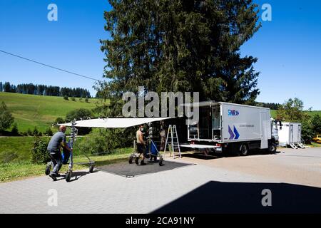 Furtwangen, Germania. 30 luglio 2020. Due membri dell'equipaggio del film rotolano una vela leggera sul set cinematografico. La serie SWR "die Fallers - Die SWR Schwarzwaldserie" è stata trasmessa dal 1994 e conta più di 1000 episodi ad oggi. La corona pandemia cambia e complica le riprese, in quanto deve essere osservato un rigoroso concetto di igiene. Credit: Philippe von Ditfurth/dpa/Alamy Live News Foto Stock