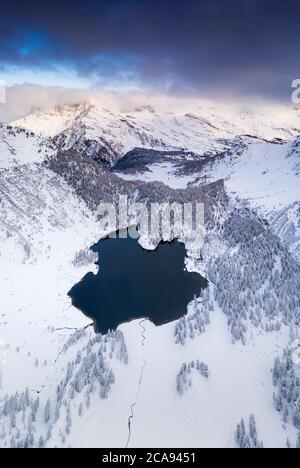 Lago Cavloc circondato da neve, vista aerea, Valle di Bregaglia, Engadina, Cantone di Graubunden, Svizzera, Europa Foto Stock