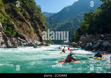 I kayakers negoziano il loro senso attraverso le rapide di whitewater sul fiume Karnali nel Nepal occidentale, Asia Foto Stock