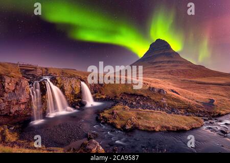 Aurora Borealis (aurora boreale) sopra Kirkjufell Mountian con una piccola cascata in Islanda, regioni polari Foto Stock