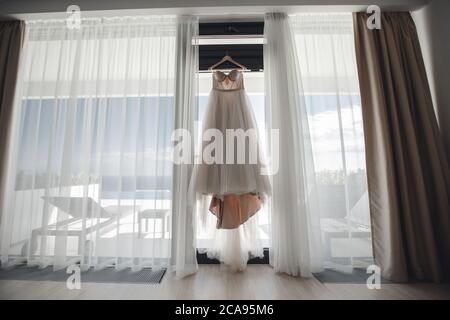 sposa mattina. abito da sposa alla finestra interna Foto Stock